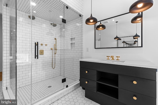 bathroom featuring large vanity, a shower with shower door, and tile floors