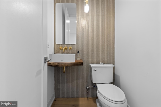 bathroom with sink, hardwood / wood-style flooring, and toilet