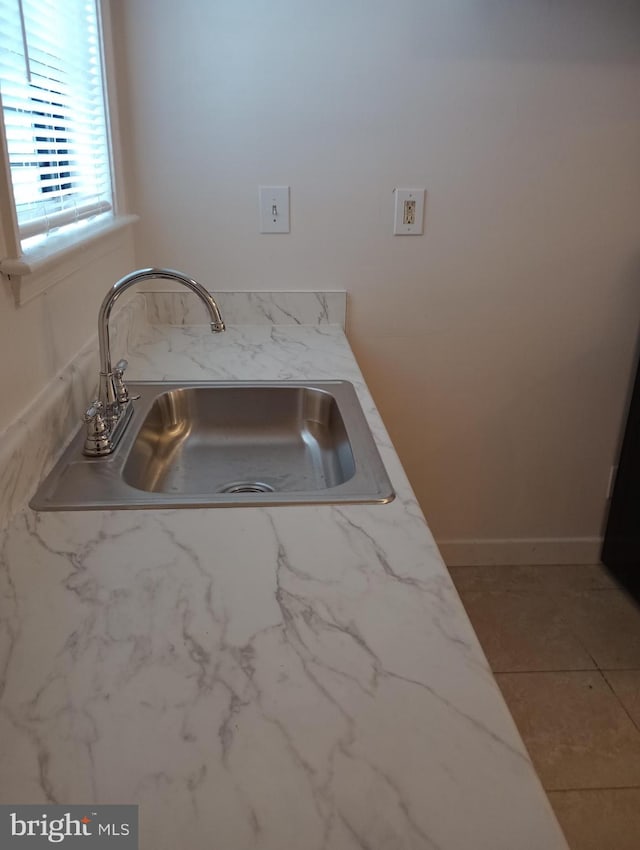 kitchen featuring sink, light stone countertops, and tile flooring