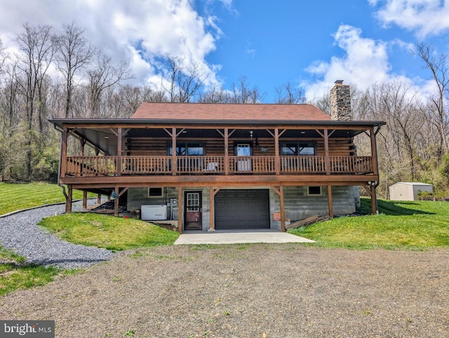 back of house featuring a garage, a deck, and a yard