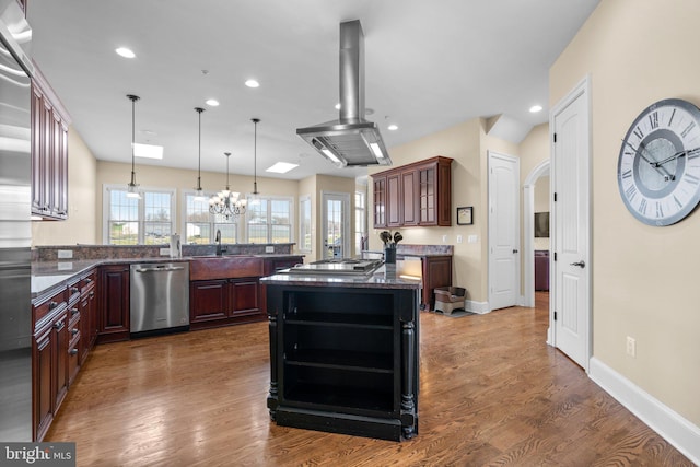 kitchen with island exhaust hood, stainless steel appliances, decorative light fixtures, a notable chandelier, and dark hardwood / wood-style floors