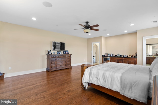 bedroom featuring ensuite bathroom, dark hardwood / wood-style floors, and ceiling fan