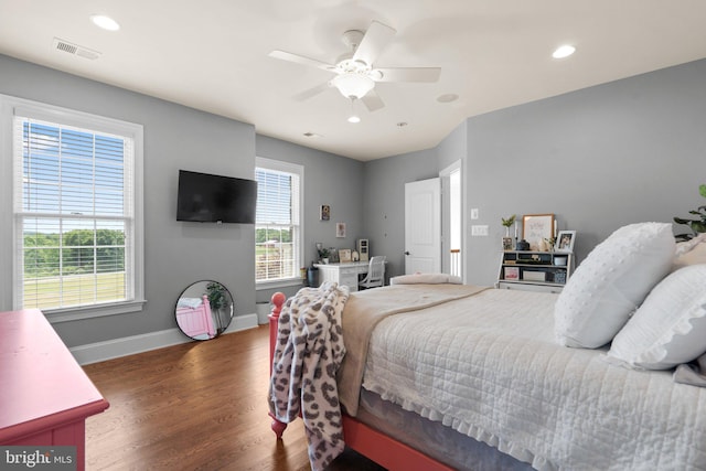 bedroom featuring multiple windows, dark hardwood / wood-style flooring, and ceiling fan