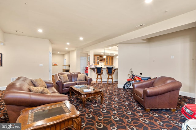 living room featuring carpet and indoor bar