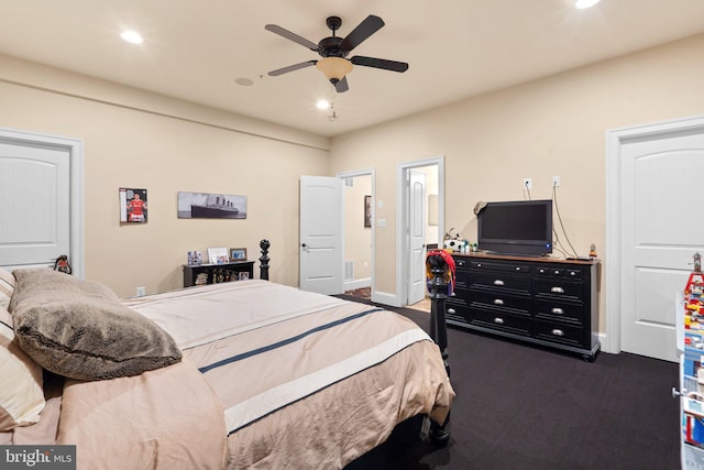 carpeted bedroom with ensuite bath and ceiling fan