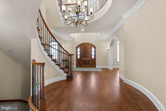 entrance foyer featuring a high ceiling, hardwood / wood-style flooring, and crown molding