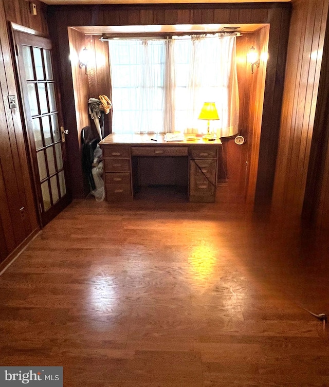 hallway with wooden walls and hardwood / wood-style floors