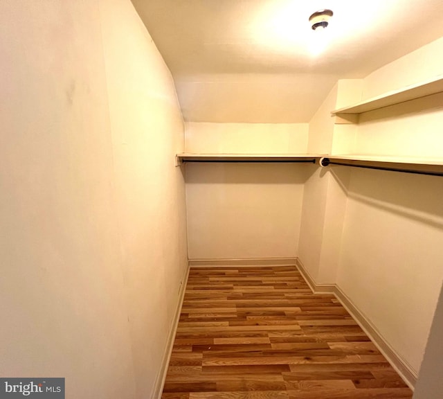 walk in closet with hardwood / wood-style flooring and lofted ceiling