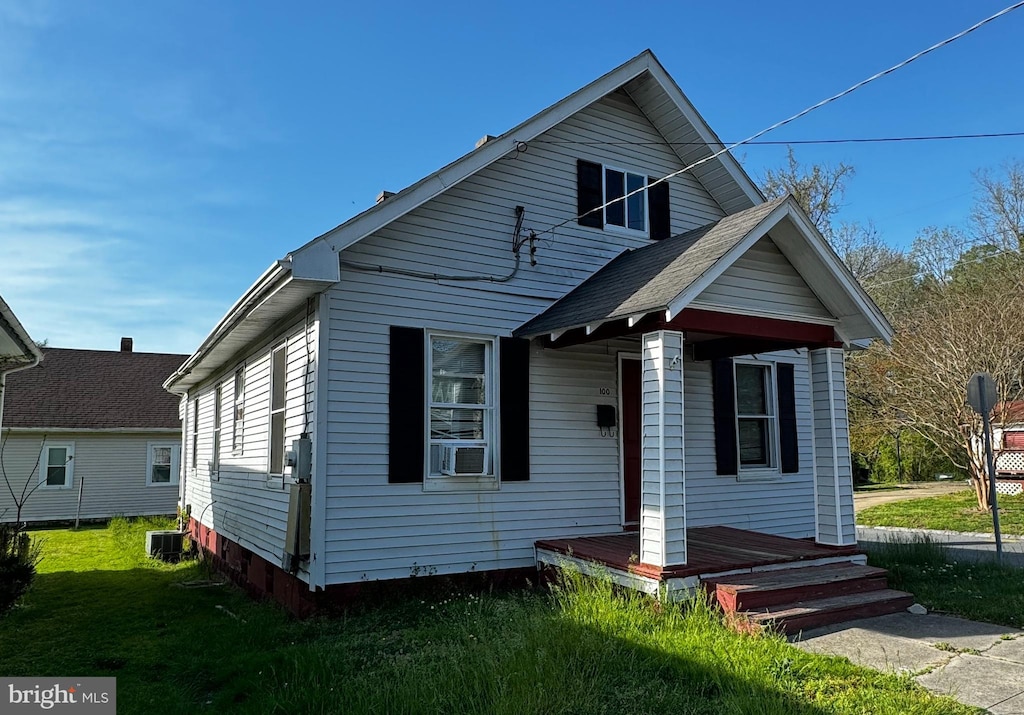 bungalow with central AC unit and a front lawn