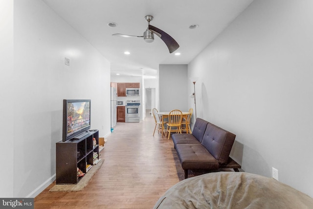 living room featuring ceiling fan and light wood-type flooring