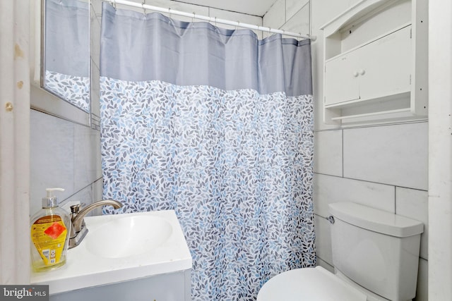 bathroom featuring tile walls, toilet, and vanity