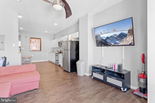 living room with light hardwood / wood-style floors and ceiling fan