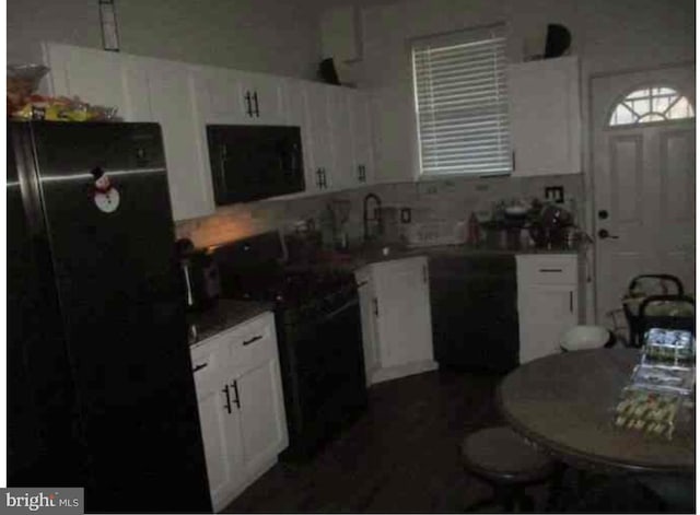 kitchen featuring white cabinets, sink, and black appliances