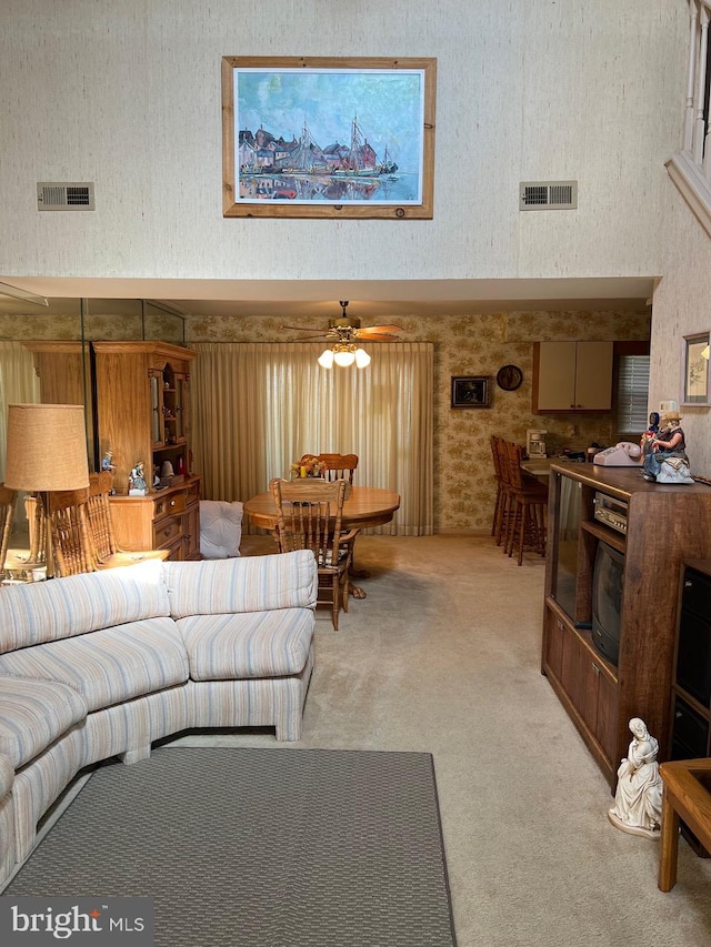 carpeted living room featuring ceiling fan