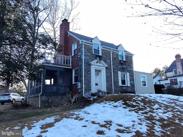 view of front of house featuring a balcony and a sunroom