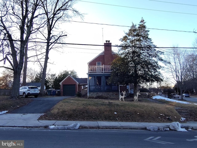 view of front of property featuring a balcony and a garage