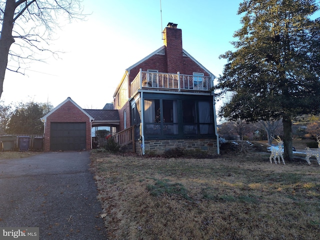 back of house featuring a balcony and a sunroom