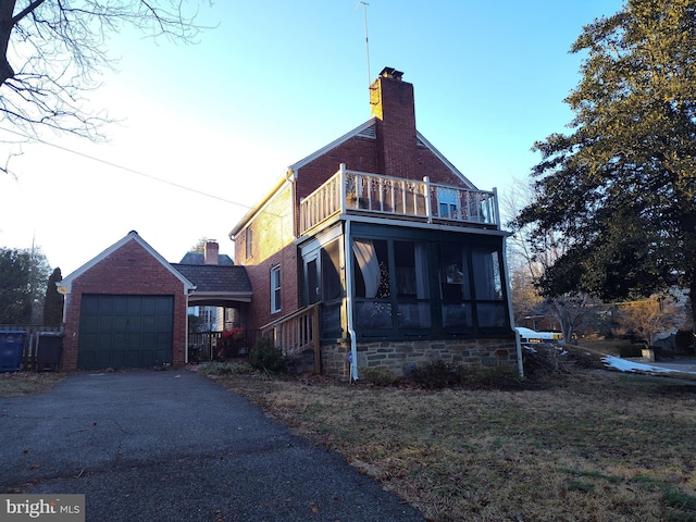 view of home's exterior with a garage, a balcony, and a sunroom