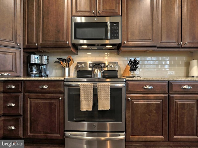 kitchen featuring appliances with stainless steel finishes, dark brown cabinetry, and tasteful backsplash