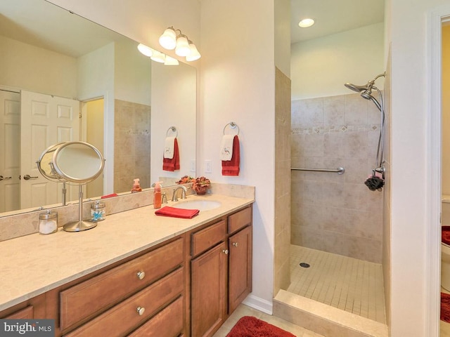 bathroom featuring vanity, toilet, and a tile shower