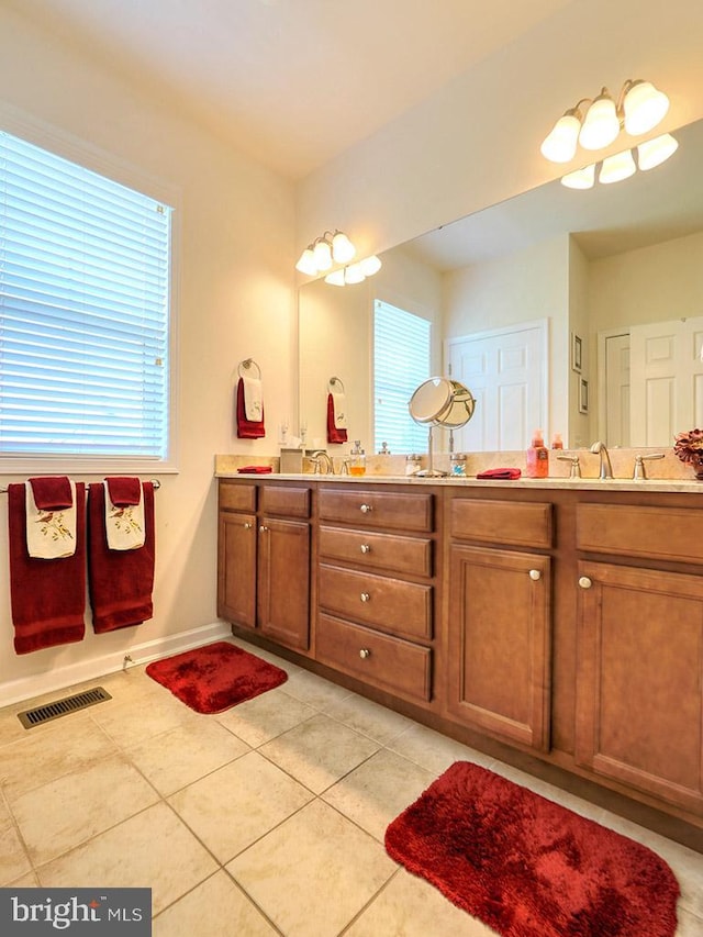 bathroom with dual bowl vanity and tile flooring