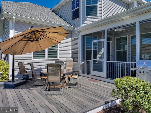 wooden deck with area for grilling and a sunroom