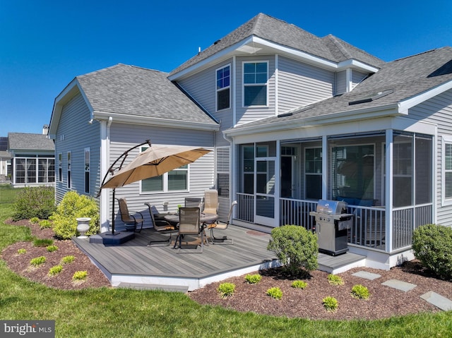 rear view of property featuring a wooden deck and a sunroom