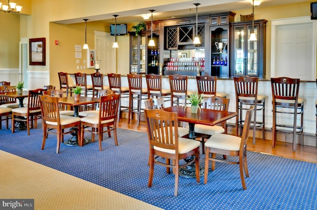 dining space featuring hardwood / wood-style flooring and an inviting chandelier