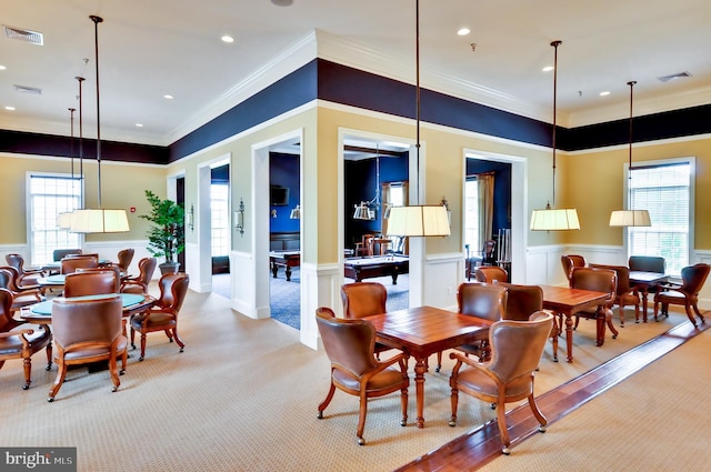 dining space with carpet floors and crown molding