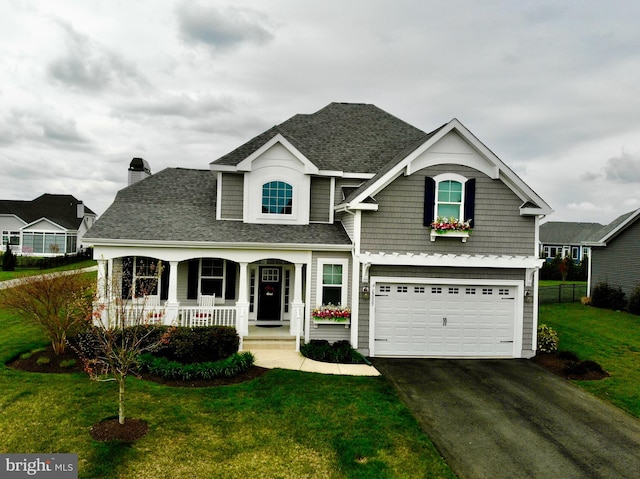 view of front of home featuring a front lawn, a garage, and a porch