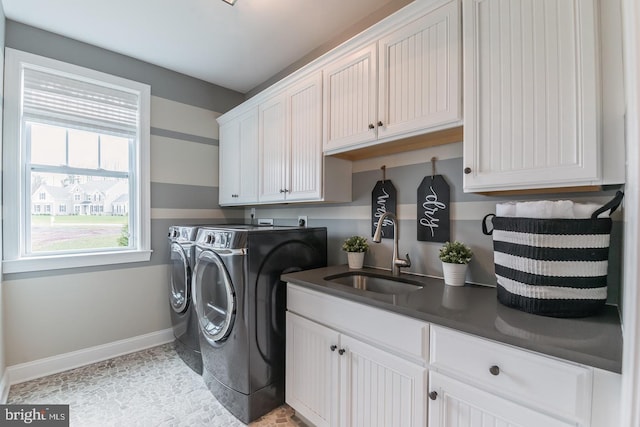 laundry area with sink, washer and dryer, light tile floors, and cabinets