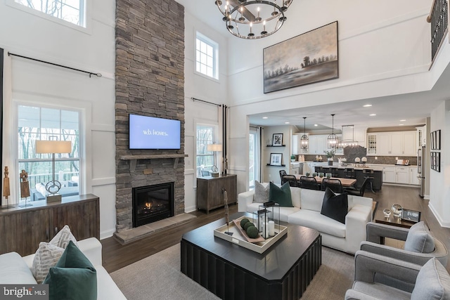 living room with a fireplace, a wealth of natural light, and dark wood-type flooring