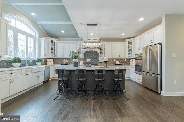 kitchen with appliances with stainless steel finishes, dark hardwood / wood-style floors, and a kitchen island