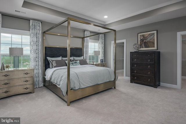 bedroom with a spacious closet, light colored carpet, and multiple windows