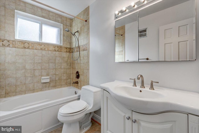 full bathroom featuring vanity, tiled shower / bath combo, and toilet