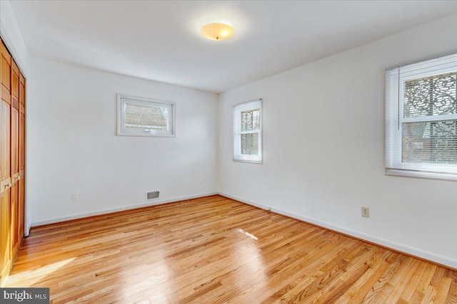 empty room with light wood-type flooring and plenty of natural light