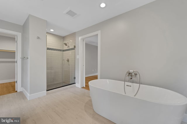 bathroom with hardwood / wood-style flooring and plus walk in shower