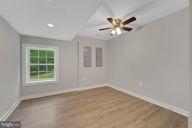 empty room featuring ceiling fan, electric panel, and light wood-type flooring