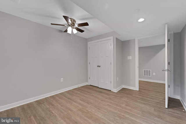 unfurnished bedroom featuring light hardwood / wood-style flooring, a closet, and ceiling fan