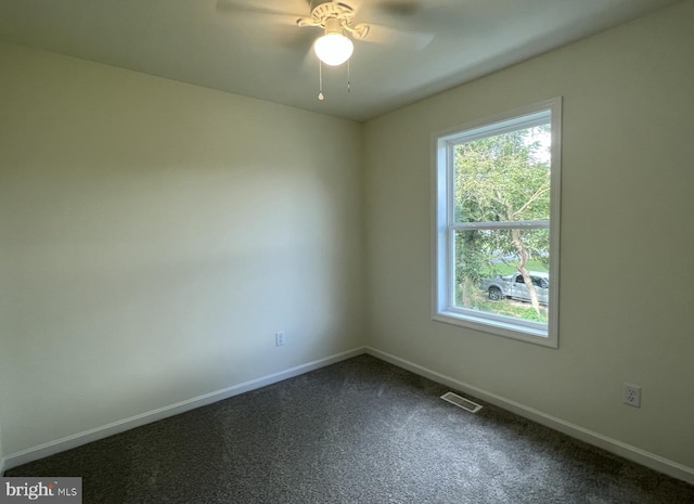 carpeted empty room featuring a healthy amount of sunlight and ceiling fan