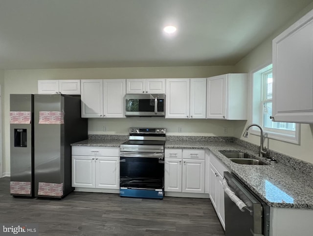 kitchen with dark wood-type flooring, white cabinets, stainless steel appliances, and sink