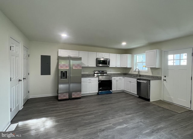 kitchen featuring dark wood-type flooring, stainless steel appliances, sink, white cabinetry, and electric panel