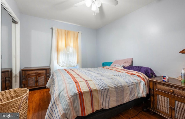 bedroom with dark hardwood / wood-style flooring, ceiling fan, and a closet