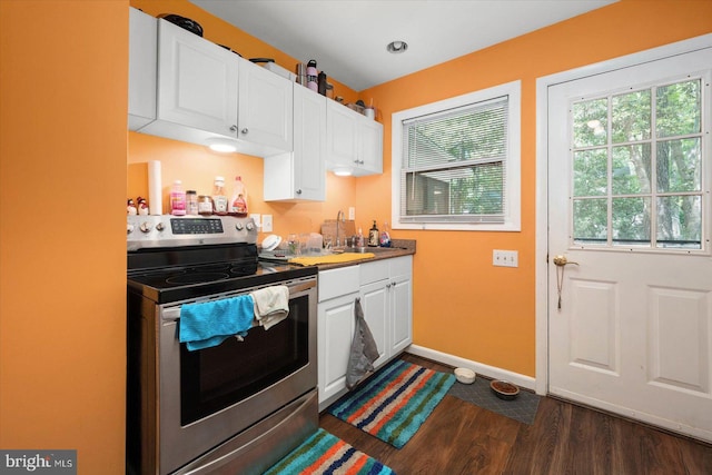 kitchen with stainless steel electric range oven, sink, dark hardwood / wood-style flooring, and white cabinetry