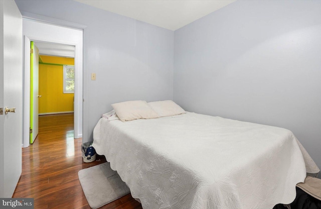 bedroom with dark hardwood / wood-style flooring