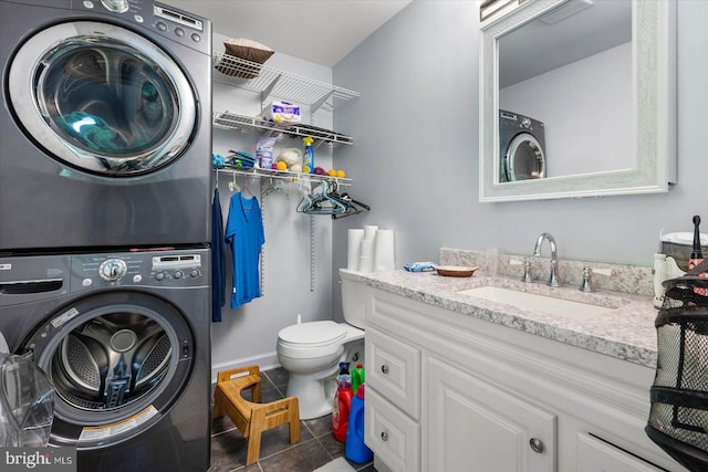 clothes washing area with sink, stacked washer / dryer, and tile flooring