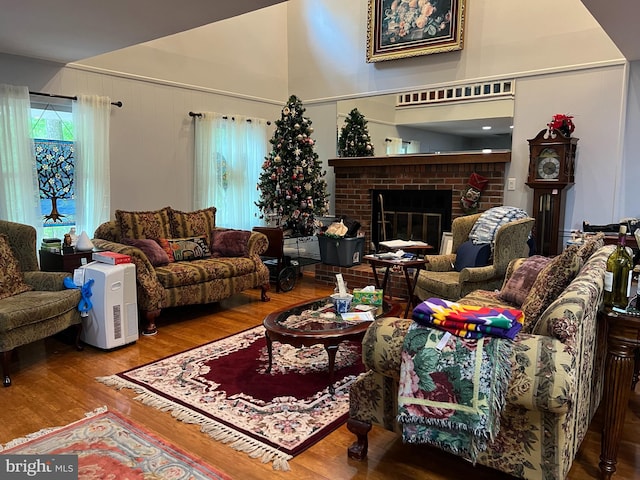 living room with hardwood / wood-style floors and a brick fireplace