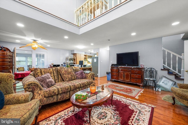 living room with wood-type flooring and ceiling fan