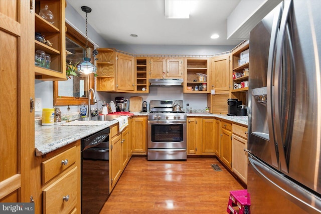 kitchen featuring light stone countertops, hanging light fixtures, light hardwood / wood-style flooring, stainless steel appliances, and sink