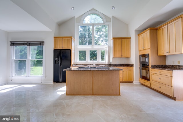 kitchen with a healthy amount of sunlight, black appliances, high vaulted ceiling, and light tile floors